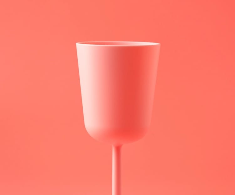 A plastic wine glass on a red background.